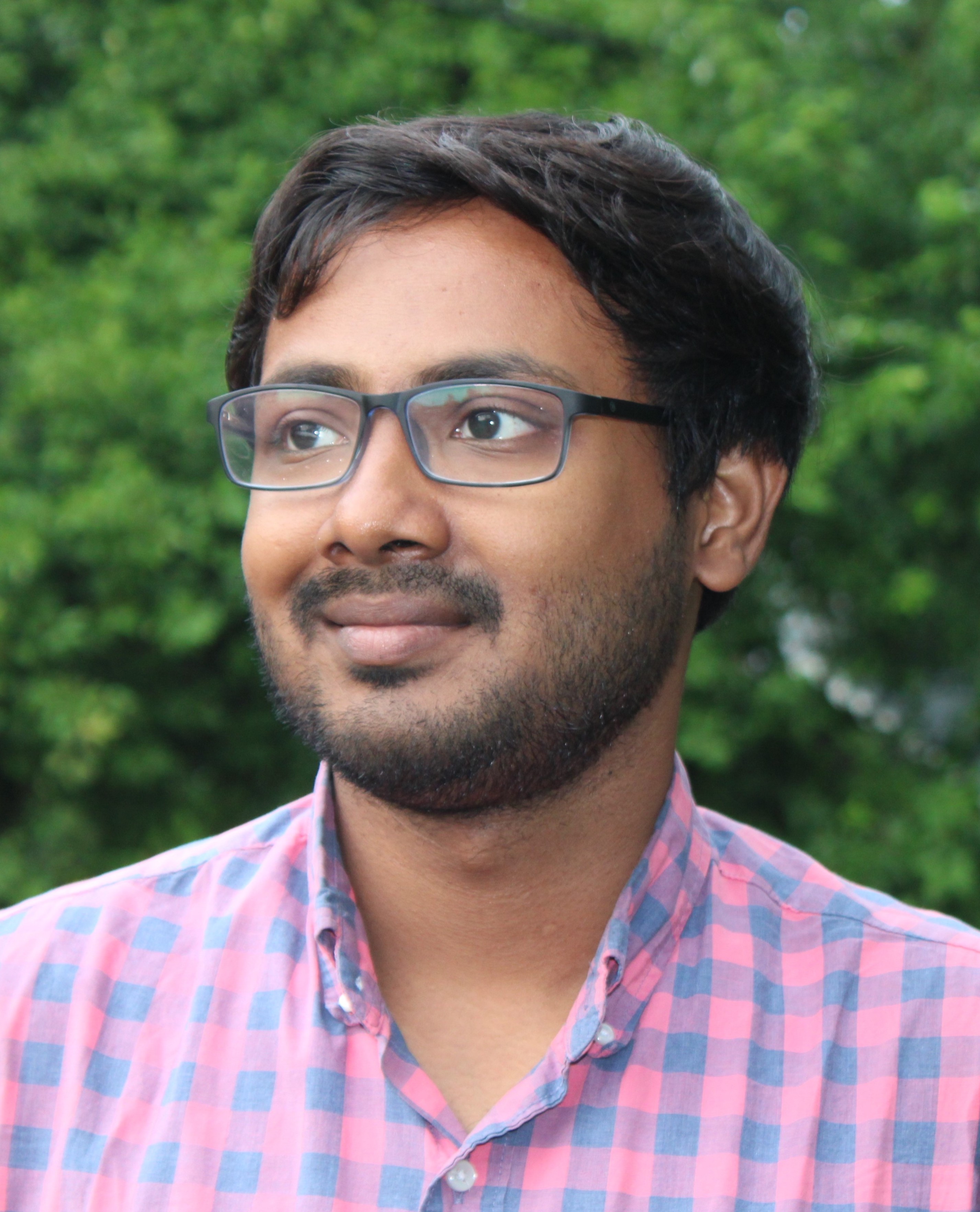 Headshot of Supriyo slightly smiling looking slighty to the left with greenery in the background