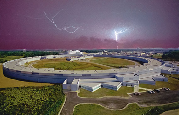 Branched forks of white lightening arc across the sky among purple clouds above the circular ring-shaped building of the advanced photon source